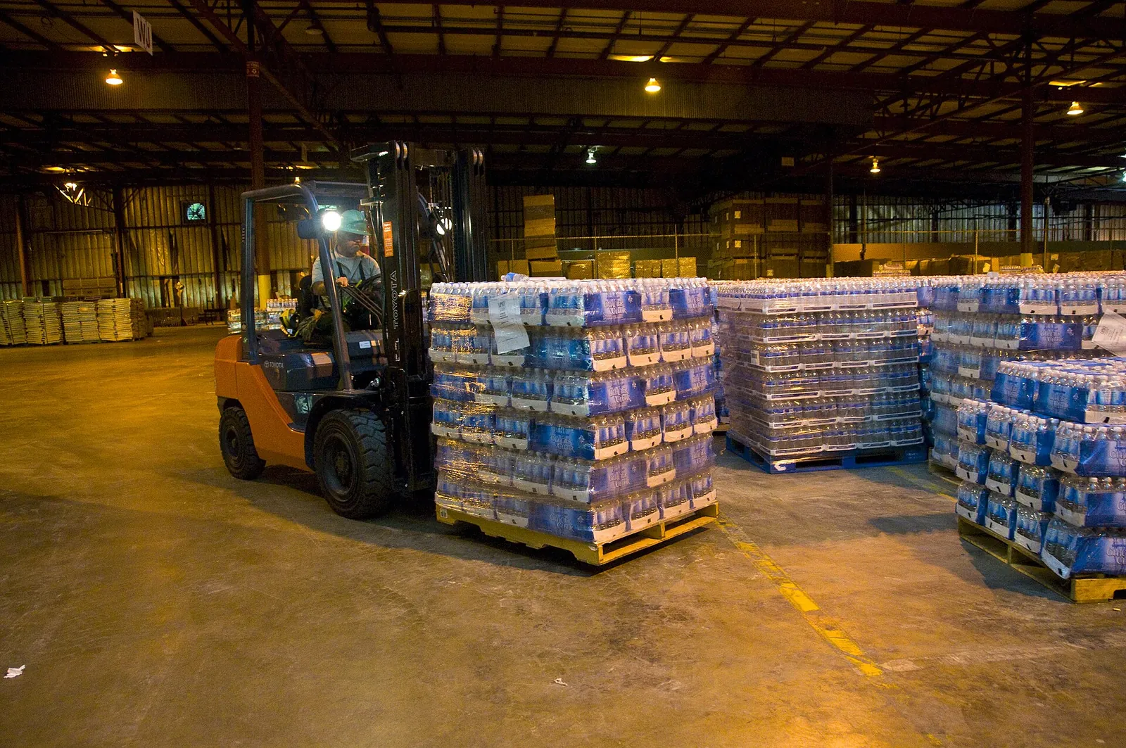 Depoda forkliftle palet taşıyan operatör